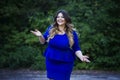 Young happy smiling beautiful plus size model in blue dress outdoors, xxl woman on nature Royalty Free Stock Photo