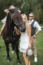 Young happy smiling family with horse. Family of four people, parents and two children, walking with a brown horse, in Royalty Free Stock Photo