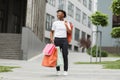 Young happy smiling fashionable African American woman, holding paper shopping bags Royalty Free Stock Photo