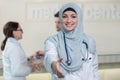 Young happy smiling female muslim doctor giving hand for handshaking. Royalty Free Stock Photo