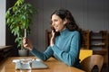 Positive female employee enjoying video chat on smartphone with friend of family during work break Royalty Free Stock Photo