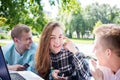 Young happy smiling girl with two male friends relaxing outdoors Royalty Free Stock Photo