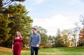 Happy pregnant couple holding hands walking outside autumn Royalty Free Stock Photo