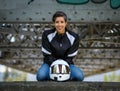 Young happy smiling pretty female motorcyclist posing on a bridge