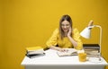 Young happy smiling student woman in yellow casual clothes reading the book at the table in library of university or Royalty Free Stock Photo