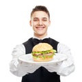 Young happy smiling waiter holding hamburger on plate Royalty Free Stock Photo