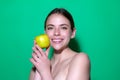 Young happy smiling woman bitting apple, healthy lifestyle. Girls holds a fresh green apple studio portrait on green