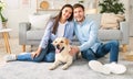 Young happy spouses with dog sitting in living room Royalty Free Stock Photo