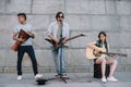 Young and happy street musicians band with guitars and djembe Royalty Free Stock Photo