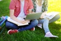 Young happy students with laptop, books and notes outdoors Royalty Free Stock Photo