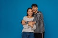 Young happy stylish guy hugging his smiling beautiful asian girlfriend Royalty Free Stock Photo