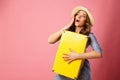 Young happy surprised beautiful woman in hat holding yellow suit Royalty Free Stock Photo