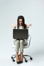 Young happy surprised businesswoman with laptop sitting on chair Royalty Free Stock Photo