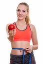 Young happy teenage girl smiling while giving red apple and meas Royalty Free Stock Photo