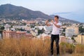 Young Happy Tourist Man Taking Picture With Phone While Standing On Hill Overlooking The City Royalty Free Stock Photo
