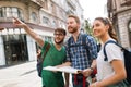 Young happy tourists sightseeing in city