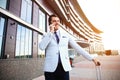 Young happy traveler businessman making call after arriving at hotel outside with his luggage. Royalty Free Stock Photo