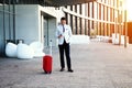 Young happy traveler businessman making call after arriving at hotel outside with his luggage. Royalty Free Stock Photo