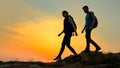 Young Happy Travelers Hiking with Backpacks on the Rocky Trail at Summer Sunset. Family Travel and Adventure Concept.