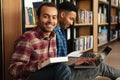 Young happy two african men students sitting in library Royalty Free Stock Photo