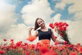 Young happy ukrainian woman holding bouquet of poppies flowers walking, enjoy sunny day in field Royalty Free Stock Photo