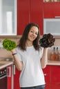 Young happy vegetarian nutritionist woman holds two types of salad in her hands, natural organic food, healthy food at home