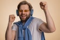 Young happy winner man listening music via headphones, dancing disco fooling around, celebrating Royalty Free Stock Photo