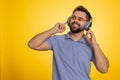 Young happy winner man listening music via headphones, dancing disco fooling around, celebrating Royalty Free Stock Photo