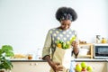 Young happy woman african american afro hair have just returned from the market. and took the tomato, lemon out of the paper bag Royalty Free Stock Photo