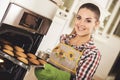 Young happy woman baking fresh cookies at kitchen. Royalty Free Stock Photo