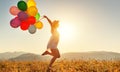 Happy woman with balloons at sunset in summer Royalty Free Stock Photo
