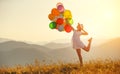 Happy woman with balloons at sunset in summer Royalty Free Stock Photo