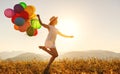 Happy woman with balloons at sunset in summer Royalty Free Stock Photo