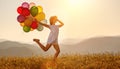 Happy woman with balloons at sunset in summer Royalty Free Stock Photo