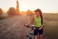 Young happy woman bicyclist riding bicycle in suburbs. Summer sport activity. Healthy lifestyle