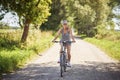 Young happy woman on a bike in countryside Royalty Free Stock Photo