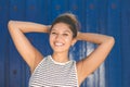 Young happy woman on blue background holding hands above head Royalty Free Stock Photo