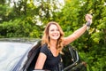 Young happy woman in the car with keys in hand - concept of buying car. Royalty Free Stock Photo
