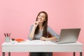 Young happy woman in casual clothes leaning chin on hand sit and work at white desk with contemporary pc laptop isolated Royalty Free Stock Photo