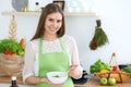 Young happy woman cooking in the kitchen. Healthy meal, lifestyle and culinary concepts. Good morning begins with fresh Royalty Free Stock Photo