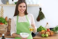 Young happy woman cooking in the kitchen. Healthy meal, lifestyle and culinary concepts. Good morning begins with fresh Royalty Free Stock Photo