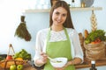 Young happy woman cooking in the kitchen. Healthy meal, lifestyle and culinary concepts. Good morning begins with fresh Royalty Free Stock Photo