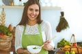 Young happy woman cooking in the kitchen. Healthy meal, lifestyle and culinary concepts. Good morning begins with fresh Royalty Free Stock Photo