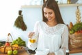 Young happy woman cooking in the kitchen. Healthy meal, lifestyle and culinary concepts. Good morning begins with fresh Royalty Free Stock Photo