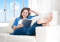 Young happy woman on couch at home enjoying using digital tablet Royalty Free Stock Photo