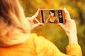 Young happy woman doing autumn selfie on smartphone for social n Royalty Free Stock Photo