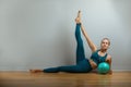 Young happy woman doing fitness exercises with fit ball at home. Slim body, stay home. Independent training. Royalty Free Stock Photo