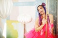 young woman with dreadlocks hairstyle wearing pink dress, doll style, bright make, up in the pink room. Royalty Free Stock Photo