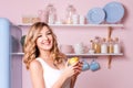 Young happy woman eating fruits at home in the kitchen. Blonde beautiful girl having her breakfast before going to Royalty Free Stock Photo