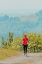 Young happy woman enjoying in a healthy lifestyle while jogging on a country road through the beautiful sunny forest Royalty Free Stock Photo